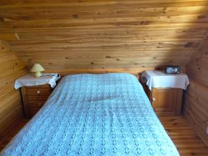 a bedroom with a bed in a wooden cabin at U Czesiuka in Jałowo