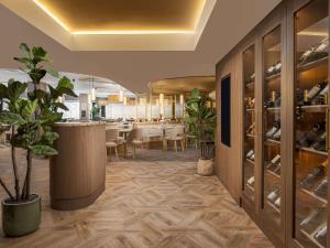 a dining room with a table and a wine cellar at Mercure London Earls Court in London