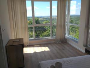 a bedroom with a large window with a view of the countryside at Villa MARRON in Priseltsi +21 photos