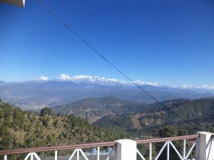 einen Balkon mit Blick auf die schneebedeckten Berge in der Unterkunft Snow View Guest House Kausani & homestay in Kausani