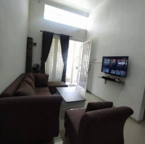 a living room with a couch and a tv at Villa Batu Permata Garden in Malang