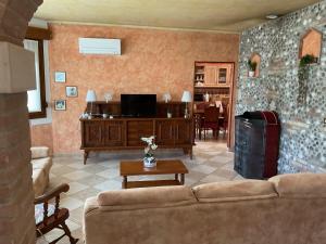 a living room with a couch and a tv at Villa tre Cai, vicina al mare e a Jesolo in Eraclea