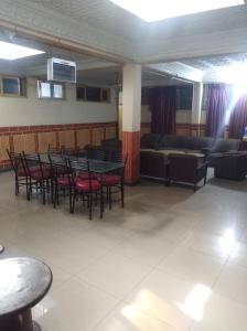 a dining room with tables and chairs and a couch at Hotel AL-Habib Islamabad in Islamabad