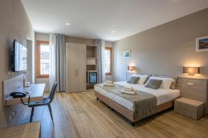 a bedroom with a bed and a desk and a chair at Villa Carducci in Comacchio