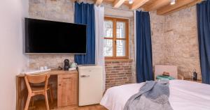 a bedroom with a bed and a desk with a tv at Oleander Trogir Suites in Trogir