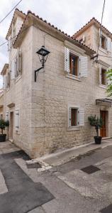 a stone building with a clock on the side of it at Oleander Trogir Suites in Trogir