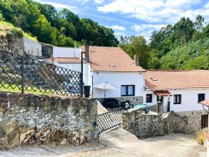 a house in the mountains with a stone wall at CASA SANTI Y LAURA in Cudillero +5 photos