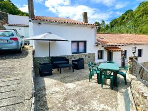 a patio with a table and chairs and an umbrella at CASA SANTI Y LAURA in Cudillero