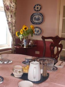 uma mesa de jantar com um vaso de girassóis em Kilbora B&B em Camolin