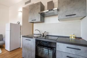 una cucina con lavello, fornello e frigorifero di Benjamin House - Exclusive Modern Loft a Bari Altre 9 foto
