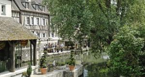 a group of people sitting on benches next to a river at Maison Saint Pierre in Chartres