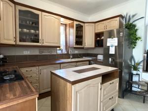 a kitchen with wooden cabinets and a black refrigerator at Levendula Vendégház in Balatonföldvár