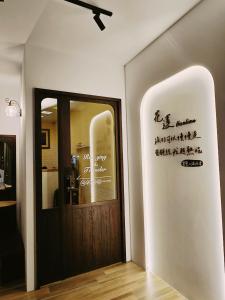 una porta in una stanza con scrittura sul muro di 旅行者之家精緻漫旅-近火車站 a Città di Hualien