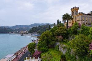 a building on a hill next to a body of water at Hotel Shelley e delle Palme, BW Signature Collection in Lerici