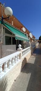 un edificio con una ringhiera bianca accanto a un marciapiede di LA SIESTA I-14 - Fincas Arena a Benidorm
