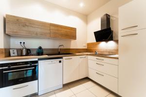 a kitchen with white cabinets and a stove top oven at Appartement T3 de Prestige proche du Jardin Public de Bordeaux in Bordeaux