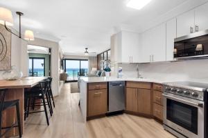 a kitchen with white cabinets and a counter top at Sundunes 122 in Navarre
