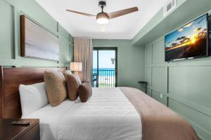 a bedroom with a large white bed with a flat screen tv at Sundunes 122 in Navarre +39 photos