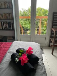 サン・ルにあるLhibiscus rougeのベッドの上に2つの花が置かれた寝室