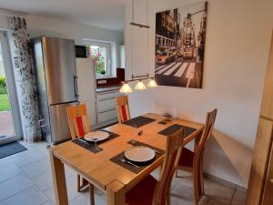 a kitchen with a wooden table with chairs and a refrigerator at DortBlick Appartement in Dortmund