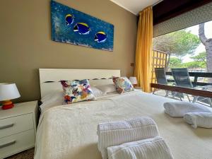 a bedroom with a white bed and a window at Beach House Riviera in Lignano Sabbiadoro