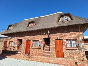un grande edificio in mattoni con tetto di paglia di Eagles Rest a Klerksdorp