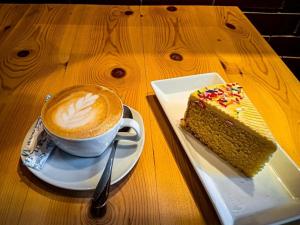 a cup of coffee and a piece of cake on a table at Coffee House Resort Dambulla,Sigiriya in Dambulla