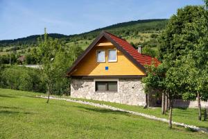 a small stone house with a red roof at Kuća za odmor Dangubica in Kuterevo