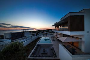 a building with a swimming pool and a sunset at Luxury villa del Sol in Novalja