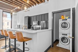 a kitchen with a washing machine and a washer and dryer at Stylish Riverfront Loft- Gym - Walk to Arch, Casino, Conventions in Saint Louis +10 photos