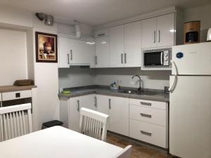 a kitchen with white cabinets and a white refrigerator at La Gloria in Guadix