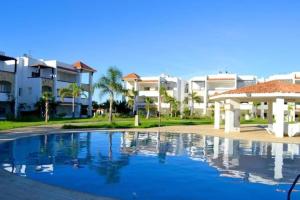 a swimming pool in front of some apartment buildings at Appartement 1 chambre vue mer latérale - Marina Golf Asilah in Asilah