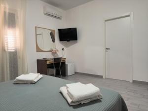 a bedroom with a bed with two towels on it at Hotel 4 Lampioni in Cropani