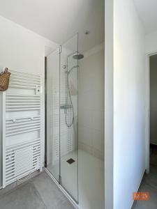 a glass shower stall in a white bathroom at Les Pins : Rez de jardin proche plage in Ambleteuse +13 photos
