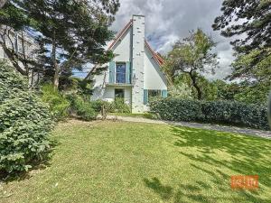 a white house with a window and a yard at Les Pins : Rez de jardin proche plage in Ambleteuse