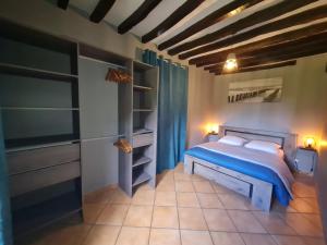 a bedroom with a bed with blue sheets and shelves at Maison Campagne Dix Kilomtres De in Hautot-lʼAuvray