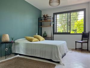 ein Schlafzimmer mit einem Bett mit gelben Kissen und einem Fenster in der Unterkunft Propriété avec vue panoramique in Montferrier-sur-Lez + 35 Fotos