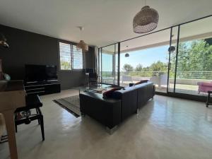 ein Wohnzimmer mit Sofa und Fernseher in der Unterkunft Propriété avec vue panoramique in Montferrier-sur-Lez