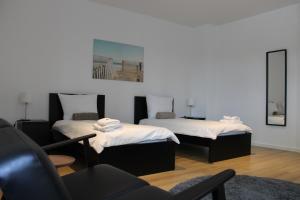 a room with two beds and a chair and a mirror at Großzügiges Zimmer im Zentrum mit 2 Betten in Paderborn