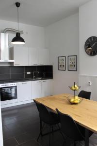 a kitchen with a wooden table and a clock on the wall at Großzügiges Zimmer im Zentrum mit 2 Betten in Paderborn