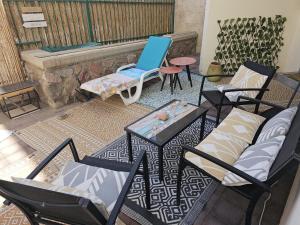 a group of chairs and a blue chair on a patio at Studio Caroline in Eilat