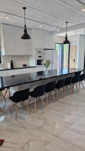 a large kitchen with a long table and chairs at Dom nad jeziorem Mazury - Pod Napięciem 2 in Mrągowo