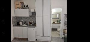a white kitchen with a sink and a toilet at Studio Caroline in Eilat