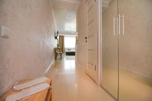 a bathroom with a glass shower stall and a hallway at Almaty Cozy Apart Hotel in Almaty +35 photos