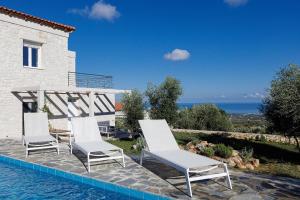 Un grupo de sillas junto a una piscina. en Komfort-Villa mit privatem Pool, en Agia Triada