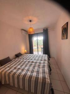 ein Schlafzimmer mit einem Bett und einem Fenster in der Unterkunft Les pieds dans l'eau in San-Nicolao + 5 Fotos