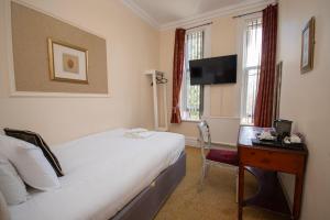 a hotel room with a bed and a desk and a television at Northop Hall Country House Hotel in Mold