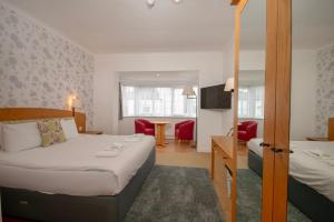 a hotel room with a bed and a living room at Northop Hall Country House Hotel in Mold