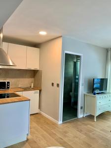 una cucina con mobili bianchi e un piano di lavoro di T2 proche des 2 Jumeaux a Hendaye