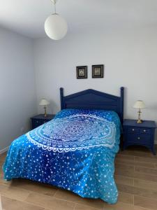 a bedroom with a blue bed and two night stands at T2 proche des 2 Jumeaux in Hendaye